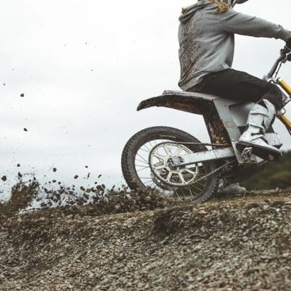 A motorcyclist riding an EV in the dirt.