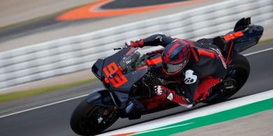 A front view of a MotoGP rider on a race track.