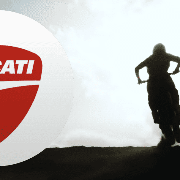 A view of a Ducati motocross motorcycle next to the brand's logo.